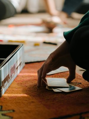 Close-up of hands playing a board game, capturing the strategy and thought involved.