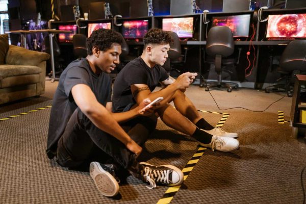 Two young men immersed in video gaming at a modern gaming arcade with high-tech computers.